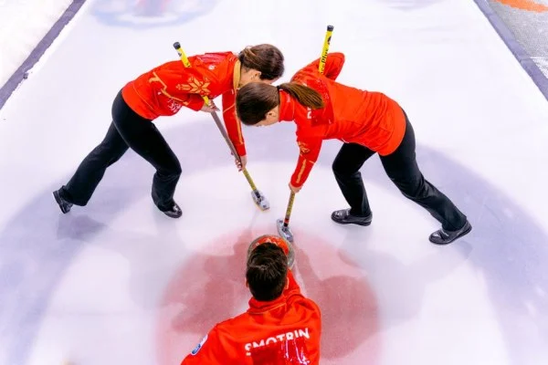 curling athletes sweeping ice
